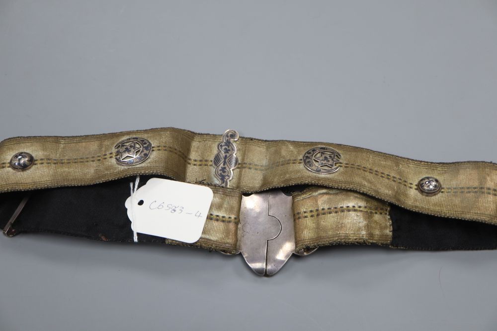 An Islamic silver and niello mounted brocade belt